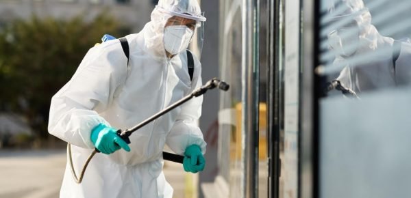 sanitation-worker-hazmat-suit-disinfecting-public-building-during-coronavirus-epidemic-min